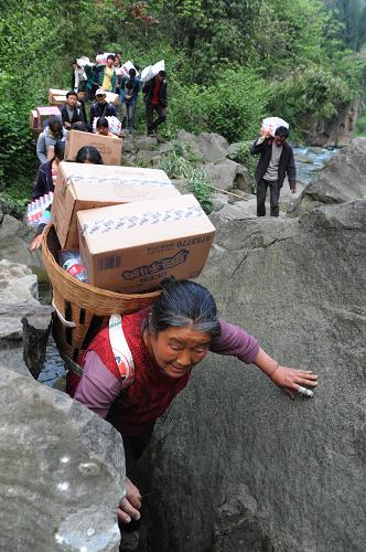 “螞蟻搬家”救災物資進孤島 4月22日,石鳳村村民在搬運救災援助物資。 地震發(fā)生以來,蘆山縣雙石鎮(zhèn)石鳳村唯一的進村道路因巨石墜落、路基塌方造成完全阻斷。這里與外界隔絕,嚴重缺少帳篷和各種食物。由于進村道路狹窄,大型工程車輛無法進入作業(yè),道路搶通救援隊多次突破都未能打通。 全村及附近村組2000多名村民藥品、食品告急。村民不等不靠,上至65歲的老人,下至7歲的孩子,迅速組織起了一支300多人的搬運隊伍,專門擔負各種救災物資的人力輸送。 據(jù)村民張彬芳介紹,出發(fā)前村民們約法三章,搬運的物資除必須留出分留給前來支援救災的解放軍和武警戰(zhàn)士外,剩下的統(tǒng)一運送、統(tǒng)一分發(fā)、照顧老弱病殘和傷員。 從道路斷口到村口5公里的路程,有很大部分是在密林山地中新開辟的道路,300多村民用“螞蟻搬家”的方式,完全靠人力將40多噸救災物資運進孤島,讓全村渡過了物資匱乏的難關(guān),且未出現(xiàn)強占為私和無序哄搶的情況。 新華社記者 李紫恒 攝