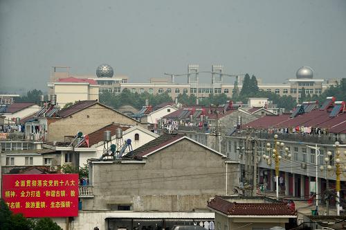 高考夢工廠 毛坦廠中學(xué)所在的毛坦鎮(zhèn)只有幾條街道,居民住宅大多是兩層的小樓,每棟樓可以隔出6、7個房間出租給外來的陪讀家長(5月24日攝)。 安徽省六安市毛坦廠鎮(zhèn)毛坦廠中學(xué)(包括其復(fù)讀校金安中學(xué),文中統(tǒng)稱為毛坦廠中學(xué))雖然是一所地處大別山山坳的鄉(xiāng)鎮(zhèn)級高中,但擁有學(xué)生近兩萬人,其中高三學(xué)生萬余人。近年來,這所鄉(xiāng)鎮(zhèn)級的高中吸引了來自安徽省內(nèi)各地的高中生以及復(fù)讀生前來就讀,其每年較高的本科達線率讓這所學(xué)校成為考生們進入大學(xué)的“夢工廠”。 毛坦廠中學(xué)建校于建國前,其真正為人所熟知卻是由于2000年以來的復(fù)讀班高考成績的不斷攀升。復(fù)讀學(xué)生們的家長口口相傳,高三年級的學(xué)生人數(shù)也從最初的幾個班幾百人發(fā)展到2013年近百個班的1萬1千余人。“毛坦廠中學(xué)的教學(xué)主要是老師對學(xué)生看的緊、要求嚴格,不放棄每一個學(xué)生。同時因為我們的生源不是最好的,并且有大量的復(fù)讀考生,所以我們的教學(xué)也是因材施教以打基礎(chǔ)為主。重點高中主要抓尖子生,而我們的目標(biāo)是讓普通生也能考上理想的大學(xué)。”毛坦廠中學(xué)副校長劉立貴介紹說。在毛坦廠中學(xué)的高三年級中,學(xué)生們自覺性很高,也隨處可見鼓勵學(xué)生不斷努力的光榮榜和