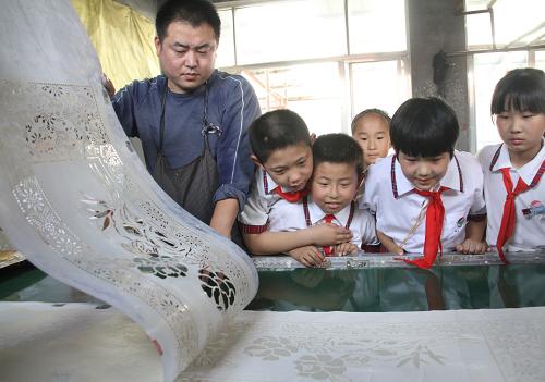 山東博興:學(xué)習(xí)“非遺” 傳承“文明” 6月6日,在山東博興縣經(jīng)濟(jì)開發(fā)區(qū)鮑莊村,民間藝人顧慧勇(左一)向小學(xué)生講解“藍(lán)印花布”的制作技藝。 當(dāng)日,山東省濱州市博興縣實(shí)驗(yàn)小學(xué)的學(xué)生在該縣經(jīng)濟(jì)開發(fā)區(qū)鮑莊村民間藝人顧慧勇的家里,參觀被列為省級非物質(zhì)文化遺產(chǎn)的“藍(lán)印花布”的制作過程,近距離感受傳統(tǒng)文化的藝術(shù)魅力,迎接6月8日我國第八個“文化遺產(chǎn)日”的到來。 新華社發(fā)(陳彬 攝)