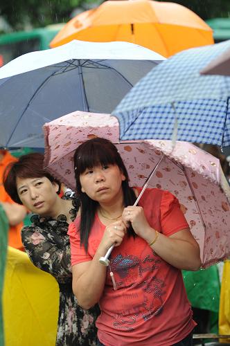 父母心 6月7日,在杭州市學軍中學考點,許多家長打傘在考點外向內張望。 當日,2013年高考拉開帷幕。考場外,隨處可見眾多陪考的考生家長。 新華社記者 鞠煥宗 攝