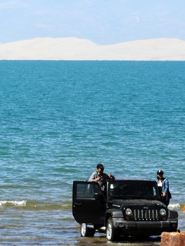 夏日的青海湖之“痛” 8月1日,游客將車開進(jìn)青海湖留影。 夏日時(shí)分,被譽(yù)為“中國最美湖泊”的青海湖旅游異?;鸨稳巳缈?。然而,在美麗的青海湖畔,由于景區(qū)管理上存在缺陷,再加上游客的一些不文明行為,給“雪域神湖”帶來傷痛,景區(qū)環(huán)保問題愈發(fā)突出。地處“世界第三極”青藏高原的青海湖是我國最大的內(nèi)陸咸水湖,是維系青藏高原東北部生態(tài)安全的重要水體,生態(tài)環(huán)境脆弱。 新華社記者 侯德強(qiáng) 攝