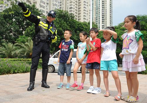 文明交通 快樂暑假 8月20日,深圳交警機(jī)動大隊(duì)的交警向參加夏令營的兒童講解交通安全知識。 當(dāng)日,深圳交警組織開展“中小學(xué)生交警夏令營”活動,參加此次活動的兒童參觀了深圳交警智能交通指揮中心,并在路面上和深圳交警機(jī)動大隊(duì)的交警一起,維持路口交通秩序,共同勸阻行人闖紅燈。 新華社記者 毛思倩攝