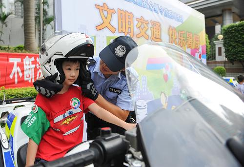 文明交通 快樂暑假 8月20日,深圳交警機(jī)動大隊(duì)的交警為參加夏令營的兒童戴上頭盔。 當(dāng)日,深圳交警組織開展“中小學(xué)生交警夏令營”活動,參加此次活動的兒童參觀了深圳交警智能交通指揮中心,并在路面上和深圳交警機(jī)動大隊(duì)的交警一起,維持路口交通秩序,共同勸阻行人闖紅燈。 新華社記者 毛思倩攝