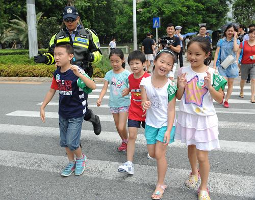 文明交通 快樂暑假 8月20日,參加夏令營的兒童在交警的帶領(lǐng)下過馬路。 當(dāng)日,深圳交警組織開展“中小學(xué)生交警夏令營”活動,參加此次活動的兒童參觀了深圳交警智能交通指揮中心,并在路面上和深圳交警機(jī)動大隊(duì)的交警一起,維持路口交通秩序,共同勸阻行人闖紅燈。 新華社記者 毛思倩攝