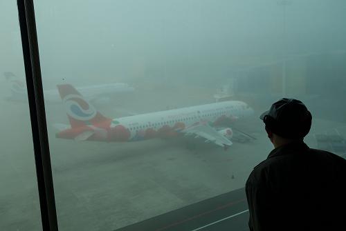 重慶大霧致機(jī)場(chǎng)近百航班延誤 12月18日,一名旅客在候機(jī)樓內(nèi)看著籠罩在大霧之中的客機(jī)。 當(dāng)日,重慶市氣象臺(tái)再次發(fā)布大霧黃色預(yù)警,預(yù)警從凌晨2時(shí)持續(xù)到11時(shí)。由于大霧造成能見度低,起降條件不足,當(dāng)日重慶江北國際機(jī)場(chǎng)進(jìn)出航班大面積受到影響。截至上午10時(shí)10分,重慶江北國際機(jī)場(chǎng)共計(jì)有80個(gè)進(jìn)出港航班出現(xiàn)延誤。 新華社記者 劉潺 攝