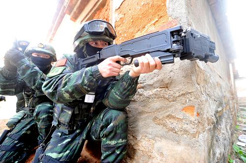廈門武警特戰(zhàn)隊舉行城市反恐實戰(zhàn)演練 廈門武警特戰(zhàn)隊員利用拐角射擊槍準備對隱蔽于街巷的”恐怖分子“發(fā)起攻擊(1月5日攝)。 1月5日,福建廈門武警特戰(zhàn)隊在廈門市湖里區(qū)五通浦口社區(qū)舉行代號為 “2014-西岸鳴鏑”的城市反恐實戰(zhàn)演練,通過偵查、排爆、破拆等課目的訓練,提高特戰(zhàn)隊員實戰(zhàn)能力。 新華社記者彭張青攝