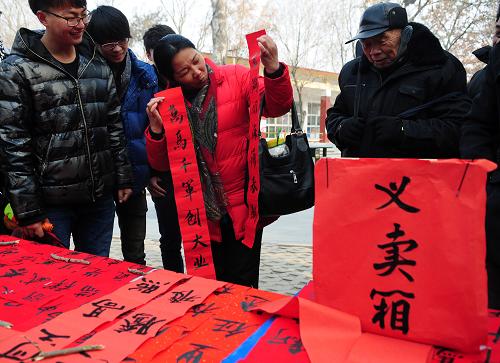 春聯(lián)義賣資助貧困學(xué)生 1月13日,在山東省聊城市人民公園,大學(xué)生志愿者在義賣春聯(lián)。 當(dāng)日,山東聊城大學(xué)美術(shù)學(xué)院組織的“義賣春聯(lián)、春節(jié)送福”活動(dòng)啟動(dòng),書法專業(yè)的20多名大學(xué)生志愿者組成4個(gè)小組,在春節(jié)前攜帶筆墨、紅紙走進(jìn)社區(qū)、鄉(xiāng)村,現(xiàn)場(chǎng)書寫春聯(lián)進(jìn)行義賣,義賣所得款項(xiàng)將全部購(gòu)買成課外讀物和學(xué)習(xí)用品,作為新年禮物捐贈(zèng)給他們?cè)?jīng)支教小學(xué)的貧困小學(xué)生。 新華社發(fā)(張振祥 攝)