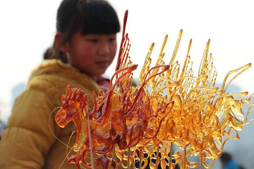 賞民俗文化 迎元宵佳節(jié) 2月11日,一名小朋友在河南省安陽(yáng)市新春民俗文化展上欣賞烙糖畫(huà)。 元宵節(jié)臨近,在河南省安陽(yáng)市新春民俗文化展上,各地民間藝人現(xiàn)場(chǎng)制作的烙糖畫(huà)、泥塑、面塑等民俗工藝品,吸引了許多游客。 新華社發(fā)(劉肖坤 攝)