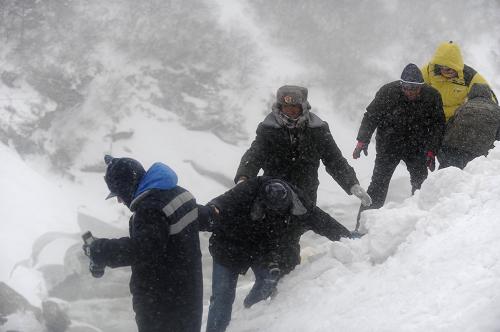 2月13日,公路部門的推土機(jī)在聶拉木至樟木鎮(zhèn)被積雪掩埋的道路上推雪。當(dāng)日午后,西藏聶拉木縣城附近又開始下起了鵝毛大雪,伴著凜冽的大風(fēng),雪花被胡亂吹起。此時(shí),在聶拉木至樟木段公路最后雪阻路段的公路搶修隊(duì)員,依然在奮戰(zhàn)當(dāng)中。這條總長度為33公里的路段,有20公里被大雪阻斷,這也是318國道中尼公路最后的雪阻路段。為了打通這條道路,西藏自治區(qū)公路局,日喀則地區(qū)交通局、公路局,聶拉木養(yǎng)護(hù)段共計(jì)140余人和武警交通部門的指戰(zhàn)員在此奮戰(zhàn)了4天的時(shí)間。截至12日21時(shí),雙向掘進(jìn)的隊(duì)伍已經(jīng)完成了其中15公里的積雪清除,剩下最后的也是最為艱險(xiǎn)的5公里路段。新華社記者 文濤 攝