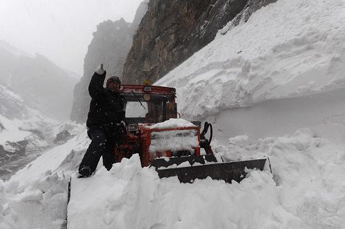 2月13日,公路部門的推土機(jī)在聶拉木至樟木鎮(zhèn)被積雪掩埋的道路上推雪。新華社記者 文濤 攝