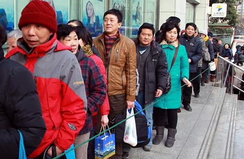 1月9日,前來購買蛇年賀歲紀(jì)念幣的上海市民在銀行門口排起長龍。新華社發(fā) (丁汀 攝)