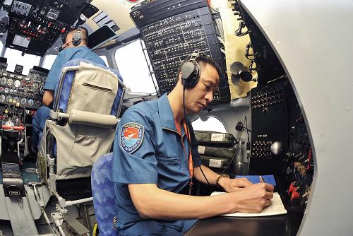 空軍航空兵在執(zhí)行人工增雨任務(wù)的飛機(jī)機(jī)艙內(nèi)操作(7月28日攝)。新華社記者 王鵬 攝