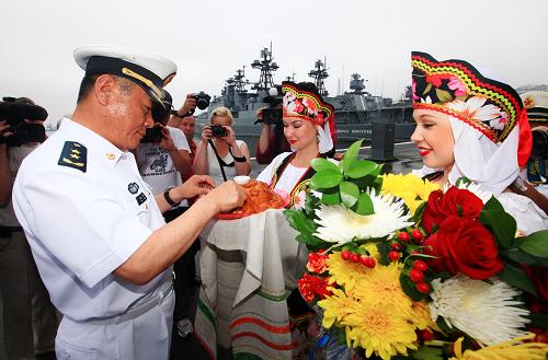 7月29日,俄羅斯姑娘向中國(guó)海軍編隊(duì)指揮員田中獻(xiàn)上面包和鮮花,用傳統(tǒng)禮儀歡迎中國(guó)海軍的到來(lái)。新華社記者 查春明 攝
