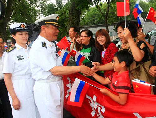 7月29日,中國海軍編隊指揮員田中(左二)在符拉迪沃斯托克港碼頭同華人華僑握手交談。新華社記者 查春明 攝