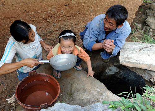 8月28日,拖巖村村民范天芬(左)一家喝上了鄉(xiāng)抗旱救災(zāi)先鋒隊(duì)送來(lái)的水。新華社記者 陳海寧 攝