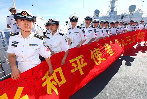 9月21日,在太平洋航行的中國海軍“和平方舟”號醫(yī)院船上,簽名儀式結束后醫(yī)護人員拉起簽滿名字的橫幅。 新華社記者 查春明 攝