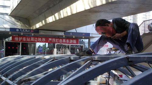 9月21日,工人在北京地鐵5號(hào)線天通苑站防雨雪棚鋼架上進(jìn)行焊接作業(yè)。新華社發(fā)(王俊峰 攝)