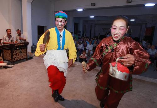 10月11日晚,家庭文藝隊(duì)隊(duì)員在為村民表演彩調(diào)劇《假報(bào)喜》。新華社發(fā)(湯林平攝)