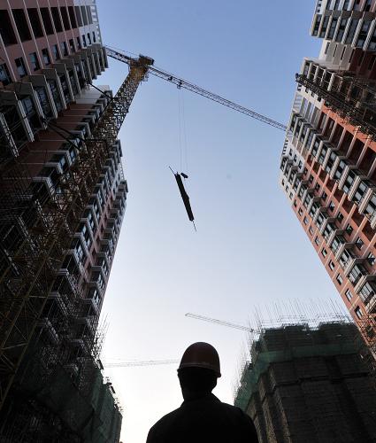 一名工人在合肥市一處公租房建設(shè)工地指揮塔吊作業(yè)(10月31日攝)。新華社記者 劉軍喜 攝