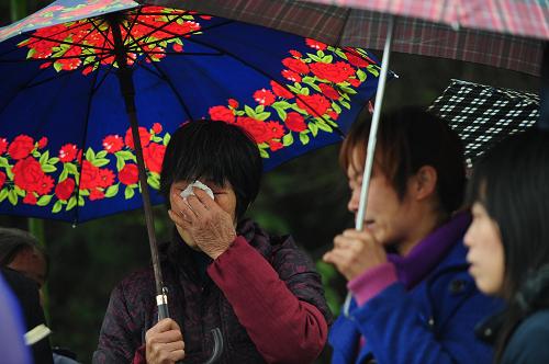 3月14日,在廣西桂平市南木鎮(zhèn)大黎村,村民在潯江岸邊等候親人的消息。新華社記者 黃孝邦 攝