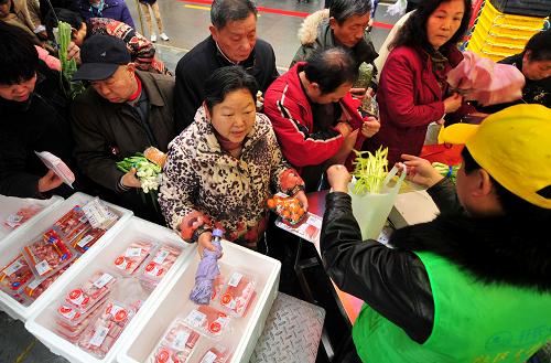 3月15日,武漢市紫潤明園社區(qū)內(nèi),市民正在蔬菜直通車前買菜。新華社記者 肖藝九 攝