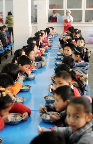 上猶縣新建的第二小學(xué)學(xué)生在吃午餐。學(xué)校目前共有1042名寄宿生,近98%的學(xué)生是留守兒童、外來(lái)創(chuàng)業(yè)和進(jìn)城務(wù)工人員子女、庫(kù)區(qū)山區(qū)的孩子(3月13日攝)。新華社記者 周科攝