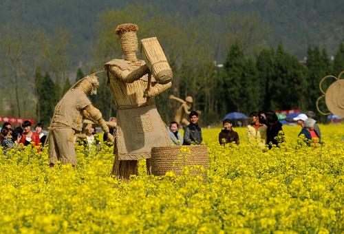 仙居縣雙廟鄉(xiāng)的大片油菜花盛開(kāi),一組反映當(dāng)?shù)厝罕姀氖聜鹘y(tǒng)農(nóng)業(yè)生產(chǎn)的稻草人豎立在其中(3月27日攝)。新華社記者 徐昱 攝