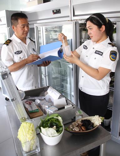5月14日,在濱州市博興縣一家餐飲企業(yè),當(dāng)?shù)厥称匪幤繁O(jiān)督管理局執(zhí)法人員使用專用速測卡檢測蔬菜是否含有農(nóng)藥殘留。新華社發(fā)(陳彬 攝)
