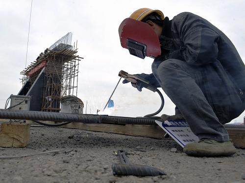 中鐵二十局集團(tuán)的建設(shè)者正在新疆首條沙漠高速公路建設(shè)工地上進(jìn)行電焊作業(yè)(5月3日攝)。新華社記者 趙戈 攝