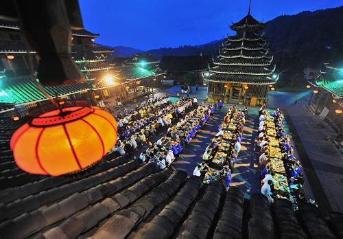 5月31日晚,廣西三江侗族自治縣林溪鄉(xiāng)冠洞村冠小屯,當(dāng)?shù)厝罕娫诠臉瞧荷蠑[出“侗族百家宴”接待游客。廣西三江侗族自治縣林溪鄉(xiāng)冠洞村冠小屯利用“侗族百家宴”民俗大力發(fā)展旅游業(yè),將傳統(tǒng)的“百家宴”作為旅游產(chǎn)品推向市場(chǎng),目前累計(jì)接待國(guó)內(nèi)外游客11萬(wàn)多人次,旅游收入達(dá)600多萬(wàn)元。“百家宴”是侗族一種特殊的飲食習(xí)俗,又名“合攏飯”“長(zhǎng)桌宴”,是侗族地區(qū)集體待客的宴席,是侗族待客的最高禮儀,在三江侗族自治縣已有數(shù)百年的歷史。新華社記者 張愛(ài)林 攝