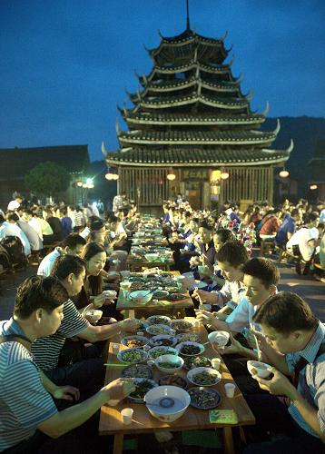 5月31日晚,廣西三江侗族自治縣林溪鄉(xiāng)冠洞村冠小屯,當(dāng)?shù)厝罕娫诠臉瞧荷蠑[出“侗族百家宴”接待游客。新華社記者 張愛(ài)林 攝