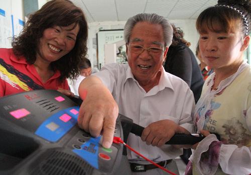 6月4日,在山東濱州市博興縣曹王鎮(zhèn)西孫村“中老年活動中心”,孫肇銀(中)在指導(dǎo)鄉(xiāng)親調(diào)試跑步機(jī)鍛煉身體。 新華社發(fā)(陳彬 攝)
