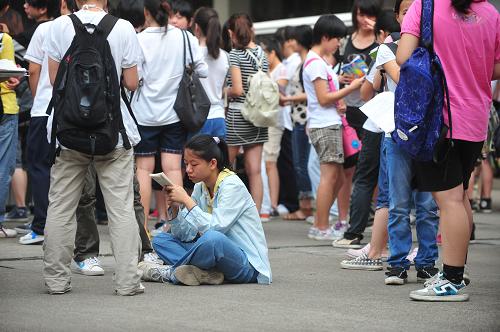 6月7日,考生在廣西南寧市第十四中考場(chǎng)外看書(shū),等候考試開(kāi)始。新華社記者 黃孝邦 攝