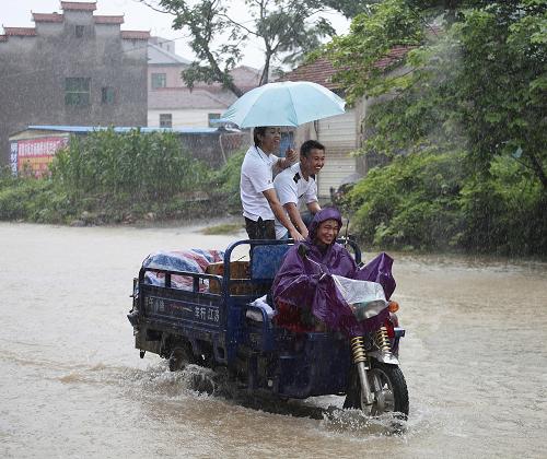 6月18日,一輛三輪車(chē)在浙江諸暨市積水的街上行進(jìn)。 新華社發(fā)(王楊鋼 攝)