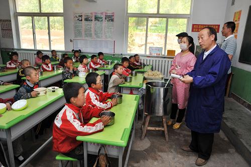 在寧夏固原市原州區(qū)張易鎮(zhèn)中心小學的教室內,學校的食堂管理員正在向孩子們公布當天的伙食標準和價格明細(6月13日攝)。新華社記者 彭昭之 攝