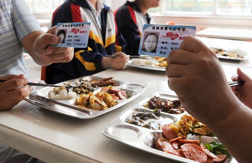 6月27日,在吉林市第十三中學食堂,享受“免費午餐”的同學在展示“愛心就餐卡”。2012年春季學期起,吉林省吉林市組織落實教育民生實事,為全市低保家庭中小學生提供在校期間午餐免費補貼。小學與初中,每生每學年按在校195天,每餐6元標準,高中與中等職業(yè)學校每生每學年按在校205天,每餐9元標準,覆蓋范圍包括城市、農(nóng)村所有中小學。新華社發(fā)(張楠 攝)