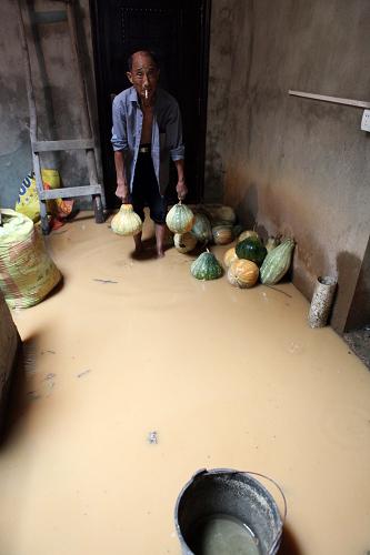 7月17日,江西省九江市都昌縣多寶鄉(xiāng)細陳灣村村民在家里搬運被洪水淹浸的南瓜。新華社發(fā)(傅建斌 攝)