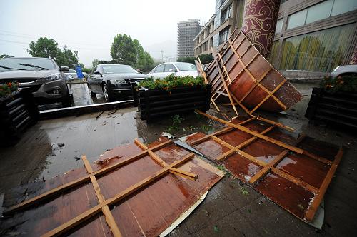 這是8月8日拍攝的臺(tái)州市三門縣街道上被狂風(fēng)吹落的廣告牌。新華社記者 鞠煥宗 攝