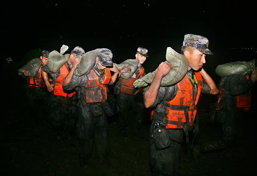 8月9日凌晨,南京軍區(qū)某裝甲團(tuán)的官兵在長(zhǎng)湖申航線長(zhǎng)興縣呂山鄉(xiāng)堤壩段加固堤壩。受臺(tái)風(fēng)“???#8221;帶來的降水影響,浙江西苕溪流域水位上漲,長(zhǎng)湖申航線長(zhǎng)興縣呂山鄉(xiāng)堤壩出現(xiàn)多處險(xiǎn)情。應(yīng)地方政府請(qǐng)求,從8月8日晚22時(shí)開始,南京軍區(qū)某裝甲團(tuán)的100多名官兵在該堤壩段排除管涌重大險(xiǎn)情2處,投填砂袋8000多個(gè),有力保護(hù)了呂山鄉(xiāng)楊吳村、燕陶村兩個(gè)村莊6000多戶村民、1萬多畝良田的安全。 新華社發(fā)(郭維虎 攝)