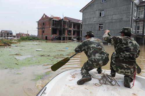 8月10日,武警湖州支隊的戰(zhàn)士在被大水淹沒的吳山村搜尋需要轉(zhuǎn)移的群眾。新華社記者 徐昱 攝