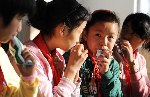 陜西省吳堡縣寇家塬鎮(zhèn)政協(xié)希望小學學生在喝牛奶(8月23日攝)。新華社記者 劉軍喜 攝