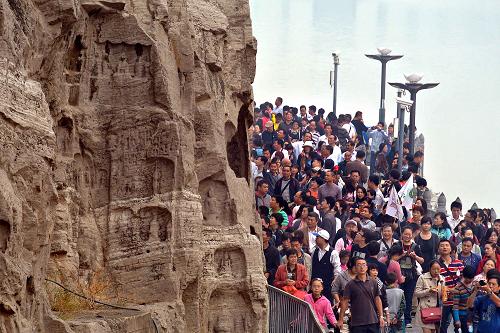 10月4日,游客在洛陽龍門石窟景區(qū)游覽。今年中秋、國慶假日期間,由于高速公路首次實行“七座以下小客車免費”政策,加之鄭武高鐵的開通,有力刺激了河南旅游市場,多數(shù)景區(qū)各項指標(biāo)創(chuàng)下新高。據(jù)河南省旅游局統(tǒng)計,“雙節(jié)”期間,全省共接待海內(nèi)外游客3670.9萬人次,實現(xiàn)旅游收入208.5億元,同比分別增長27.09%、32.5%。新華社記者 王頌 攝