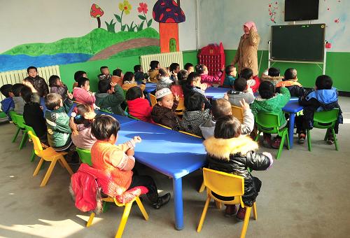 11月29日,大河家幼兒園中班的小朋友在上英語(yǔ)課。甘肅臨夏回族自治州積石山保安族東鄉(xiāng)族撒拉族自治縣的大河家鎮(zhèn)民族幼兒園坐落在離縣城幾十公里外的山溝里。2012年秋季,在當(dāng)?shù)卣馁Y金支持下,這個(gè)曾經(jīng)在農(nóng)戶小院里招生的民辦幼兒園搬進(jìn)了占地6畝的新園址,教師增加到了13名?,F(xiàn)在,有253名漢族、東鄉(xiāng)族、保安族、撒拉族、回族、土族的小朋友在這里上學(xué)。2010年,積石山保安族東鄉(xiāng)族撒拉族自治縣實(shí)施從幼兒園到高中包吃、包住、包學(xué)習(xí)費(fèi)用的“三包”教育政策,民辦幼兒園也被納入其中。民辦幼兒園不僅在建設(shè)上得到資金和政策支持,其教師培訓(xùn)學(xué)習(xí)也和公辦幼兒園教師同時(shí)進(jìn)行。新華社記者 黃文新 攝