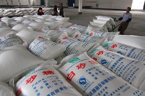 12月9日,在廣西柳州市融安縣一制糖企業(yè),工人將成袋的白砂糖運(yùn)進(jìn)倉(cāng)庫(kù)。 新華社發(fā)(鄧克軼 攝)