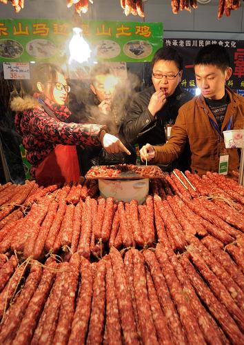 1月10日,在特色農產品展會現(xiàn)場,與會人員在現(xiàn)場品嘗香腸制品。 新華社記者 李健 攝