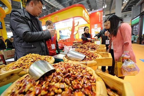 1月10日,在特色農產品展會現(xiàn)場,與會人員品嘗蠶豆制品。 新華社記者 李健 攝