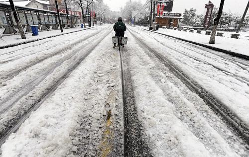 2月19日,騎車人在江蘇蘇州街頭冒雪騎行。新華社發(fā)(杭興微 攝)