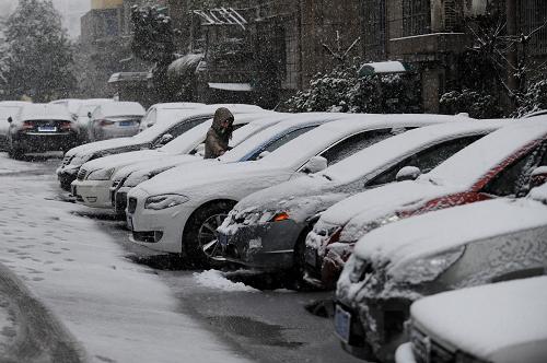 2月19日,一位杭州市民在清理車輛上的積雪。新華社記者 鞠煥宗 攝