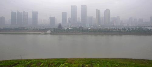 雨霧中的長沙湘江橘子洲拱極樓和附近沿江建筑(2月20日攝)。新華社記者 龍弘濤 攝