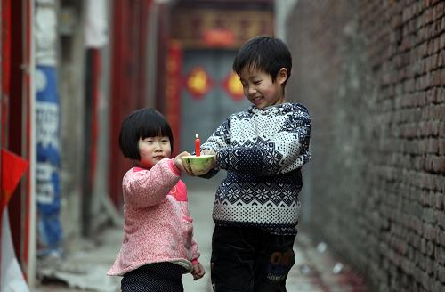 2月20日,河南省安陽(yáng)市湯陰縣兩名小朋友在玩蘿卜花燈。新華社發(fā)(常中正 攝)